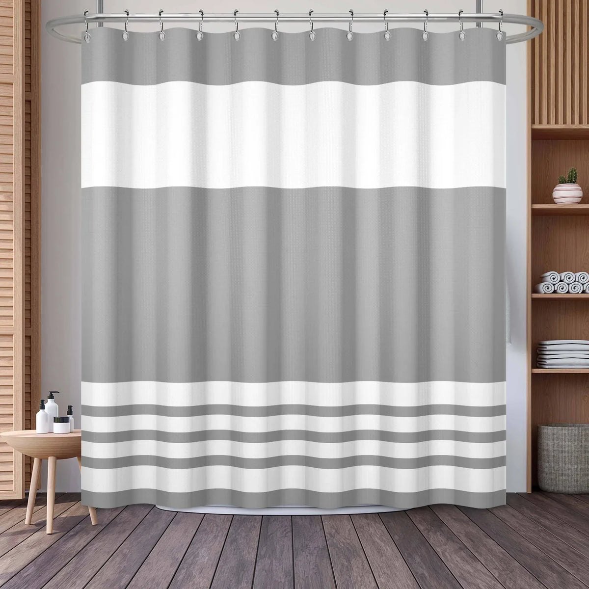 A shower curtain featuring a striped pattern of light gray and white horizontal bands.