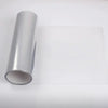 A roll of smoke black headlight and taillight tint film lying on a white surface.