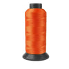 A spool of bright orange heavy-duty nylon sewing thread for upholstery and denim.