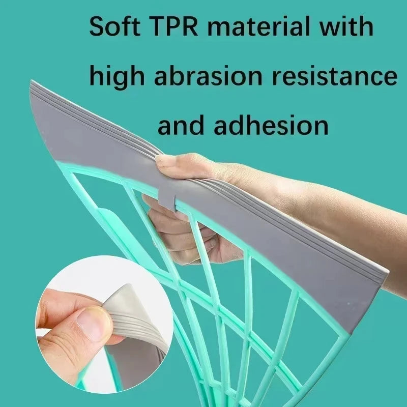A hand is holding a silicone squeegee broom with a long adjustable handle, showing the material's texture and structure.