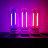 Three glass bulbs glowing with purple and pink light on a black surface