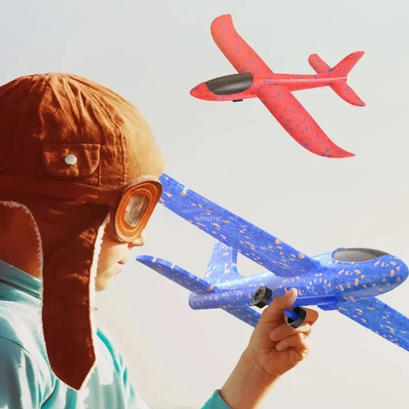 A child is looking up at a red foam glider plane toy that is flying in the air.