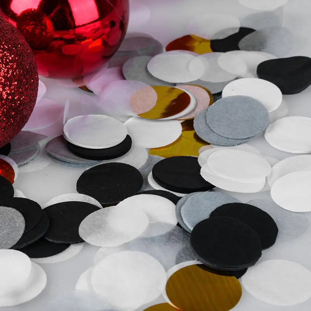 Nahaufnahme von buntem Papierkonfetti, einschließlich rot, silber, gold, schwarz und weiß.