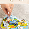 A hand is assembling a wooden farm animal toy featuring a truck, pumpkin, and other elements with a screwdriver and wrench.