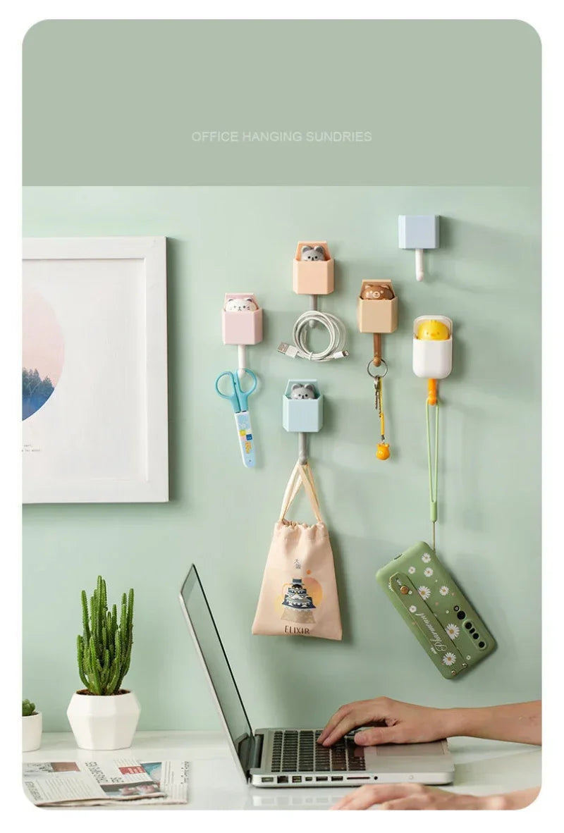 Office hanging sundries featuring adorable cat-shaped adhesive hooks on a light green wall.