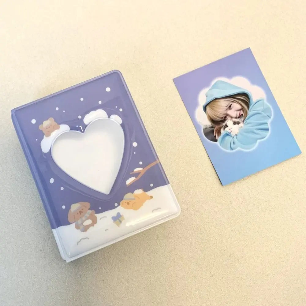 A purple photo album with a heart cutout and bear designs, next to a card featuring a person in a blue hoodie.