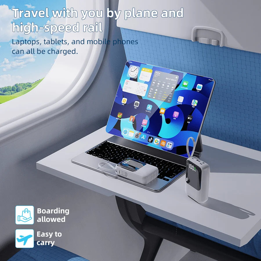 Ein Laptop lädt Mobiltelefone und Tablets über eine Powerbank in der Kabine eines Flugzeugs auf.