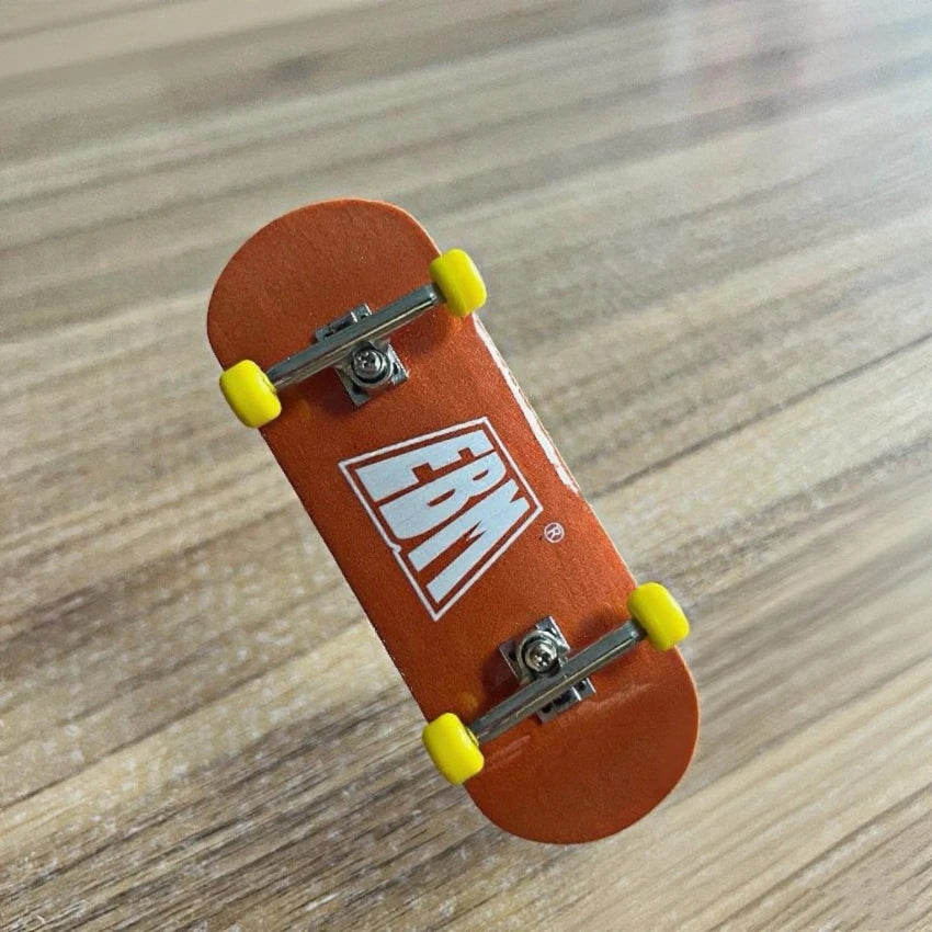 An orange skateboard with a wooden fingerboard and realistic yellow trucks resting on a light wood surface.