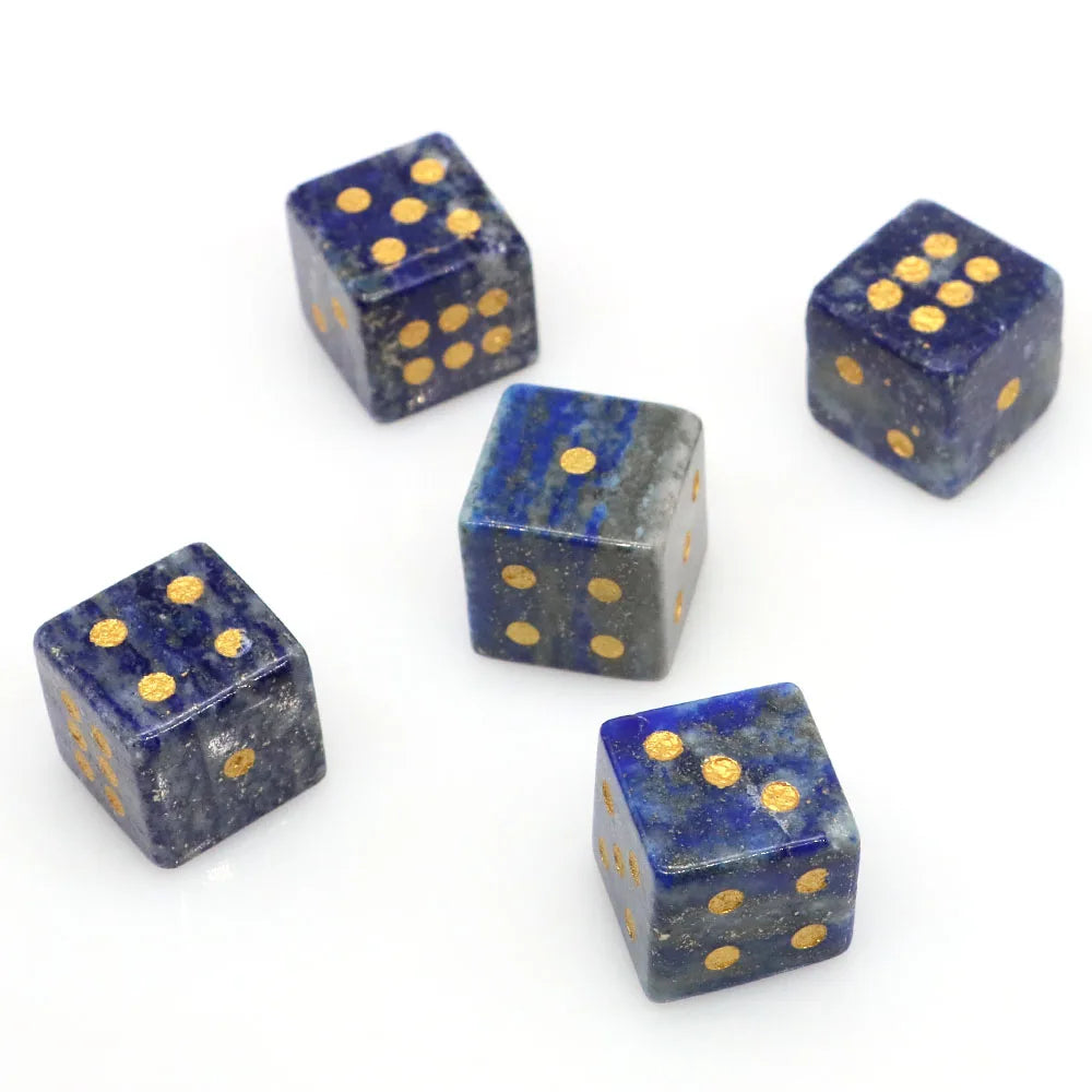 A collection of six natural stone dice featuring blue lapis lazuli and obsidian with gold dots.