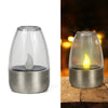 A silver solar-powered flameless LED tea light with a clear glass dome and a glowing yellow flame inside.