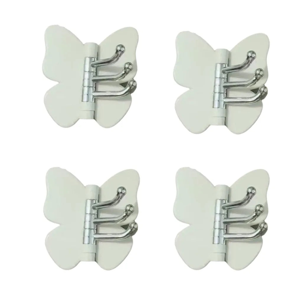 Un juego de ganchos decorativos de mariposa giratoria en metal plateado y plástico blanco.