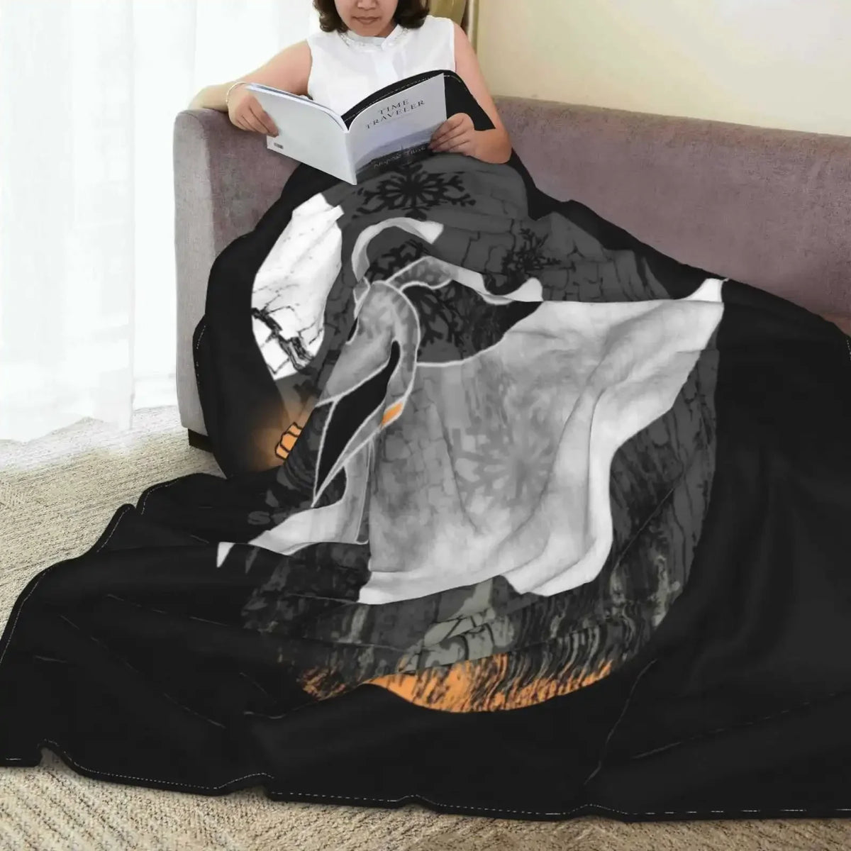 A black blanket featuring a white silhouette of a bird in flight and dark, textured patterns.
