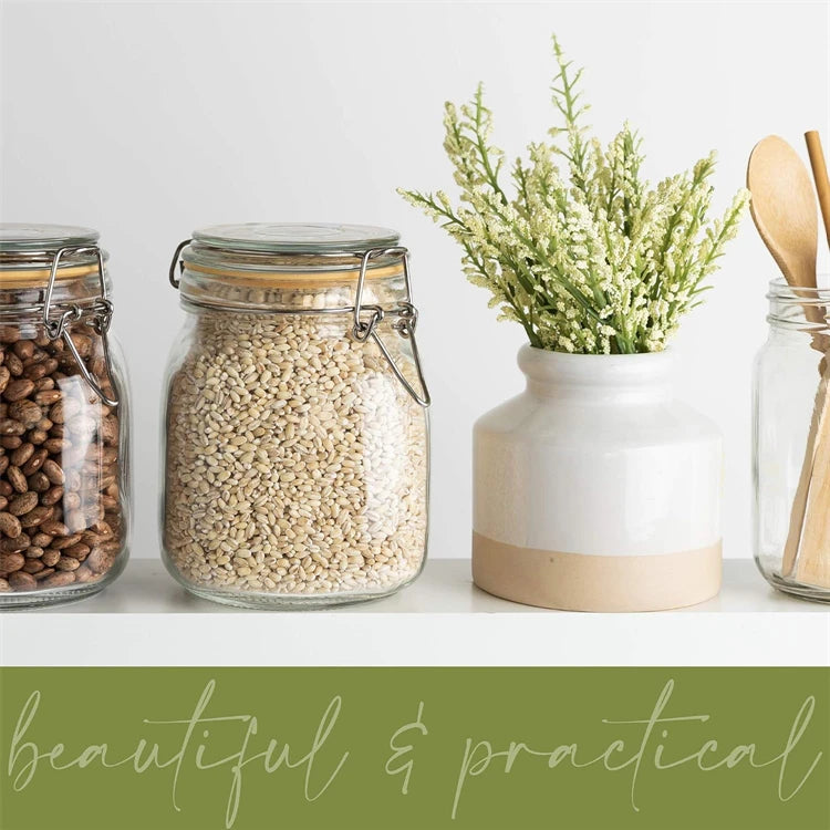 A collection of dried seeds and a bundle of green foliage displayed on a white shelf.