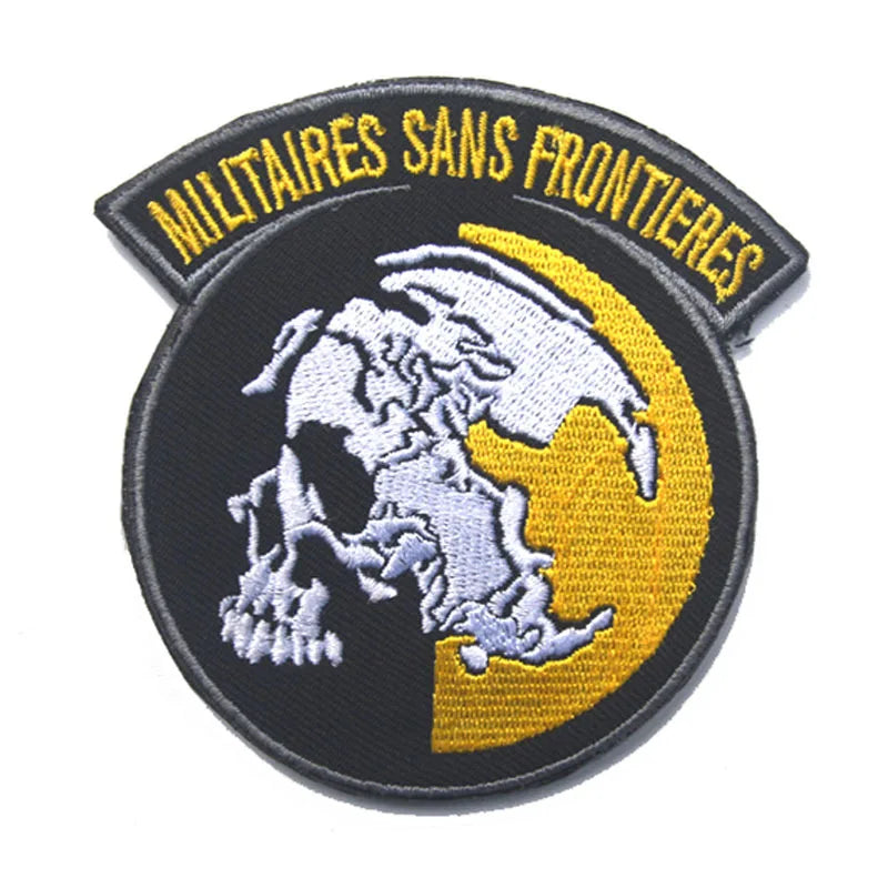 Black embroidered patch featuring a white skull and crossbones silhouette against a yellow circle, with text above it.