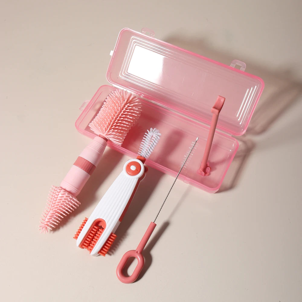 A pink silicone baby bottle cleaning set with a brush and a cleaning tool displayed in an open plastic case.