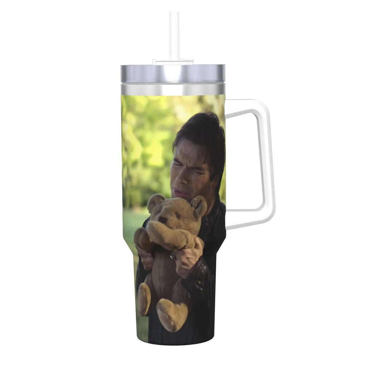A clear tumbler filled with green liquid and a man holding a teddy bear is visible.