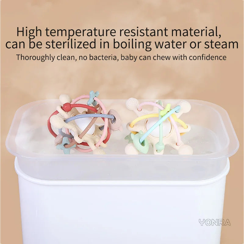 Silicone sensory rattle balls in various colors are shown inside a clear container for baby development