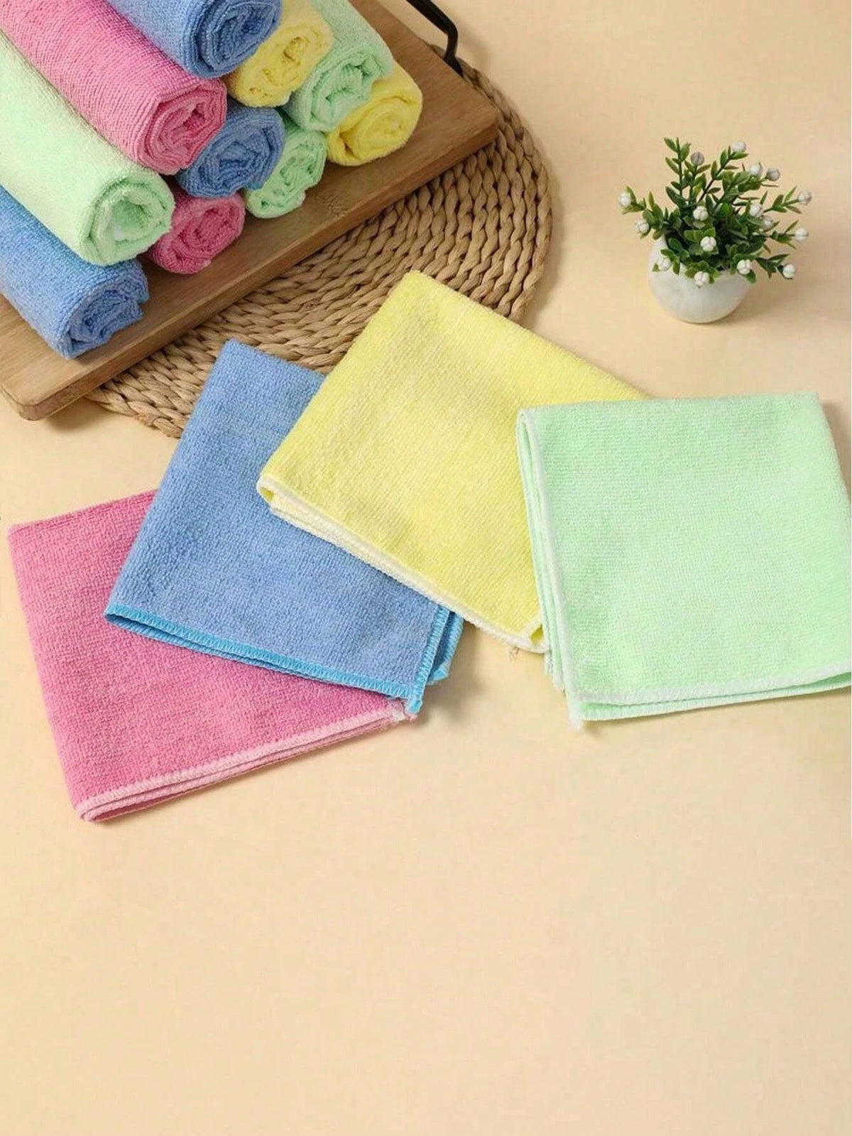 A collection of colorful microfiber cleaning cloths in various shades including pink, blue, yellow, and green, arranged on a 
