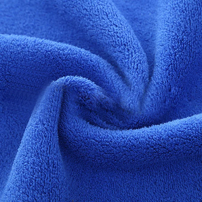 A close-up of a deep blue ultra-absorbent microfiber car drying towel folded and textured.