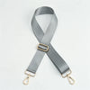 A gray nylon bag strap with a gold buckle and metal clasps.