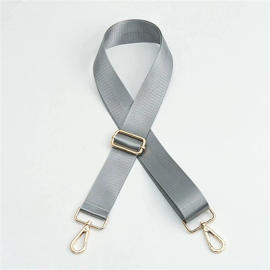 A gray nylon bag strap with a gold buckle and metal clasps.