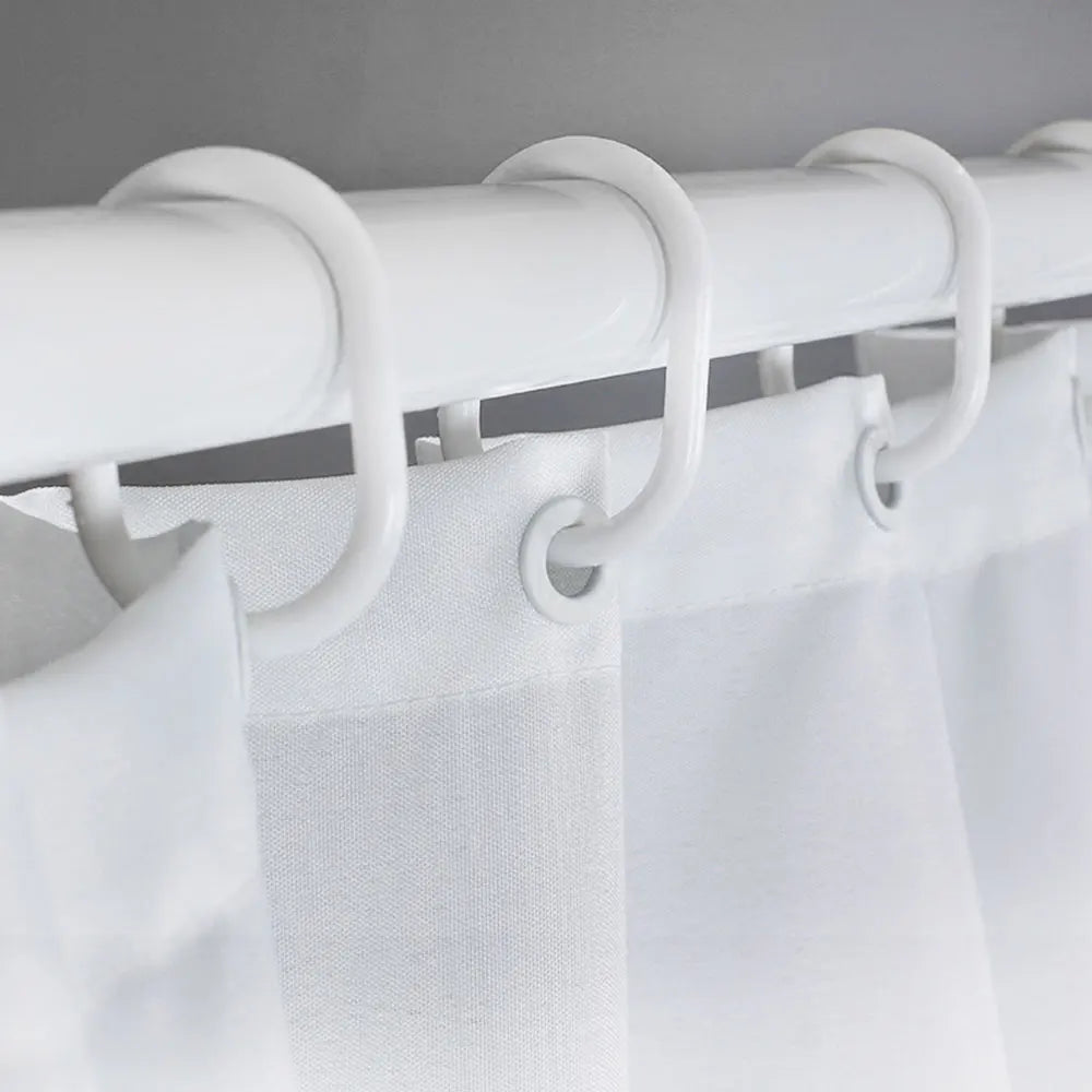 White shower curtain with leopard print fabric hanging from a white rod and hooks