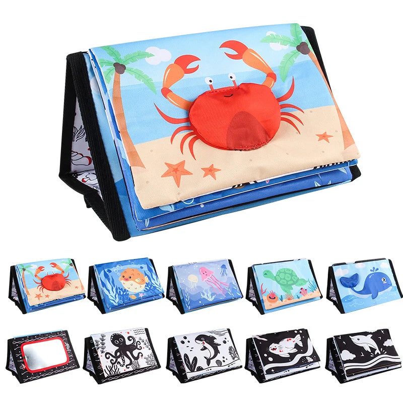 A high-contrast crinkle cloth book with a tummy time mirror for babies featuring sea creatures.