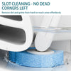 A white toilet brush is cleaning blue scouring pads in a sink, removing dirt from corners.