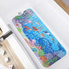A colorful cartoon bathtub mat featuring sea creatures and fish placed inside a white bathtub.