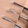 Close-up of professional scalloped lace scissors with various blade sizes marked 3mm, 5mm, and 7mm resting on brown paper.
