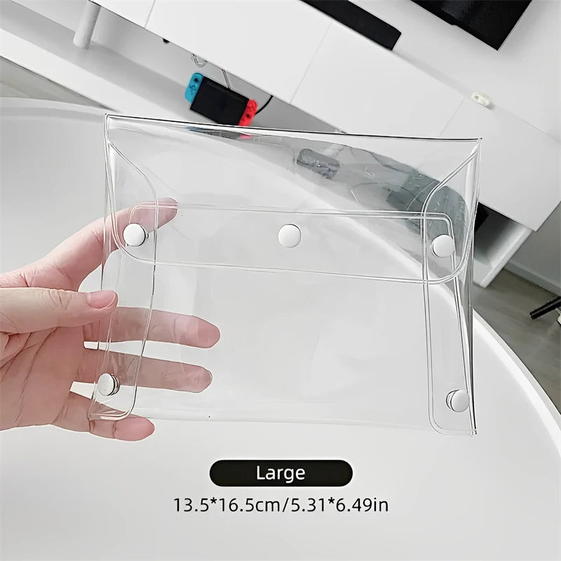 A hand holds a clear transparent PVC cosmetic bag designed for waterproof storage of makeup brushes and other items.