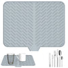 A silicone dish drying mat with a drainage ramp and a set of cutlery shown on the mat.