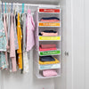 A white hanging closet organizer with five labeled pockets for daily clothing, organized by the days of the week.