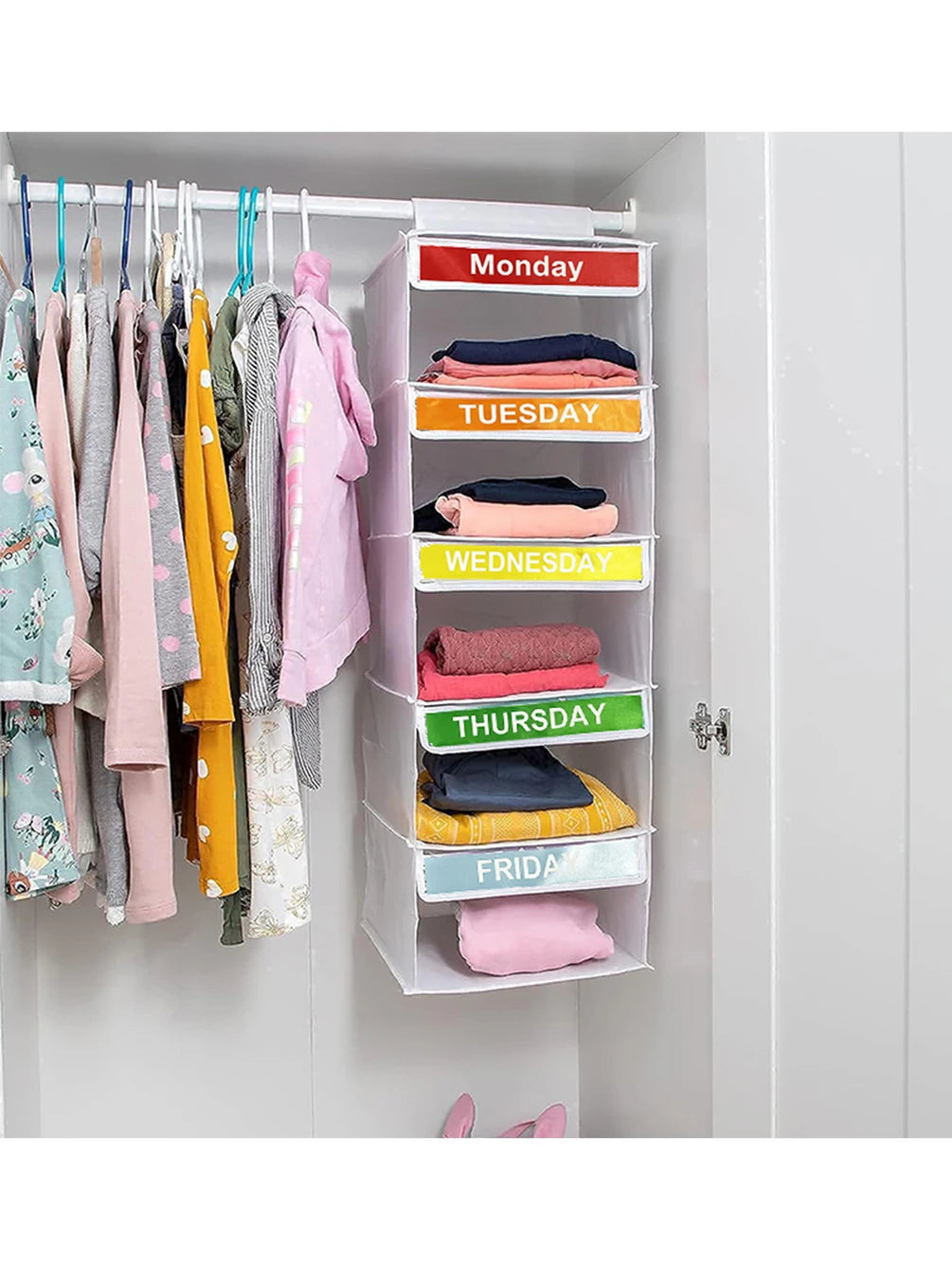 A white hanging closet organizer with five labeled pockets for daily clothing, organized by the days of the week.