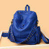 A deep blue soft leather backpack featuring silver rivets and a drawstring closure.