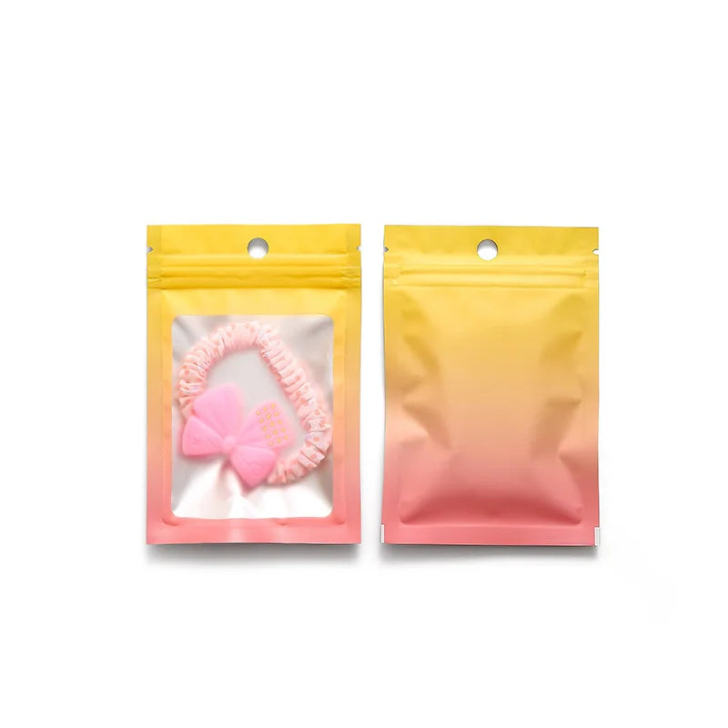 Two yellow and pink gradient resealable zipper pouches with clear windows displayed side by side.