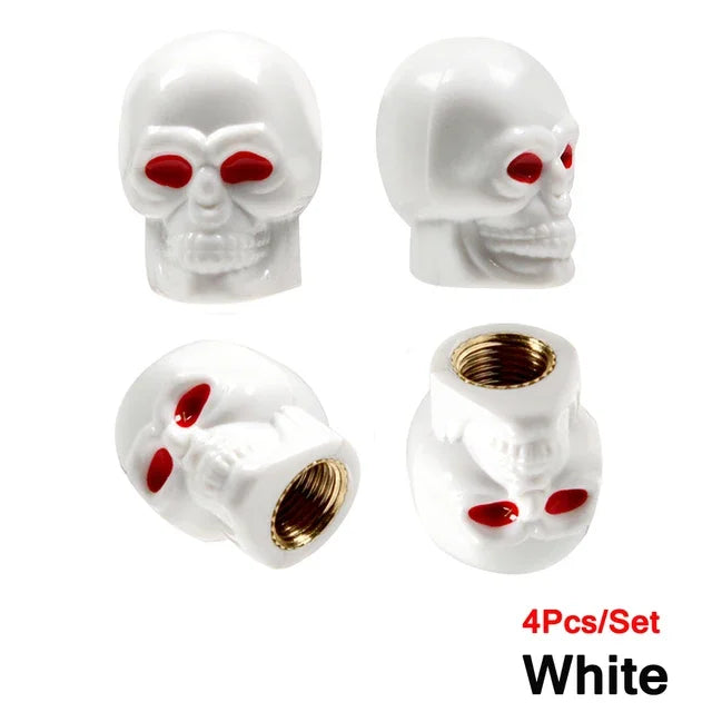 A set of four white skull design tire valve stem caps with red accents.