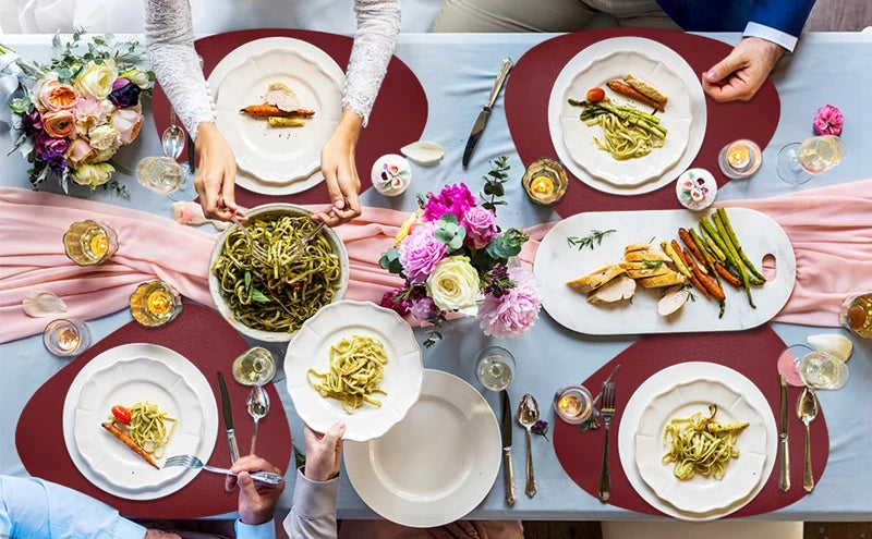 A close-up of a dining table set with food and tableware on reversible non-slip placemats.