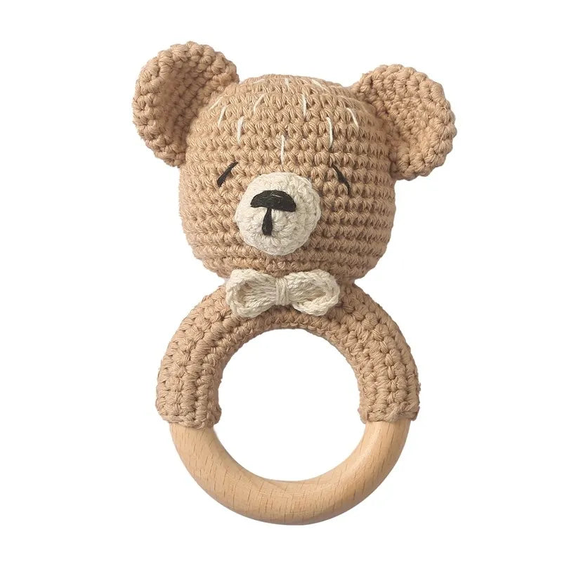 A handmade crochet bunny rattle featuring a natural wood teether ring.