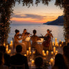 A group of people are seated outdoors enjoying a sunset view with LED pillar candles.