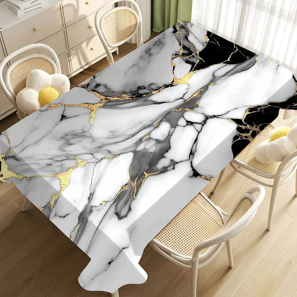 A black and white marble pattern with gold veins is displayed on a tablecloth in a room setting.