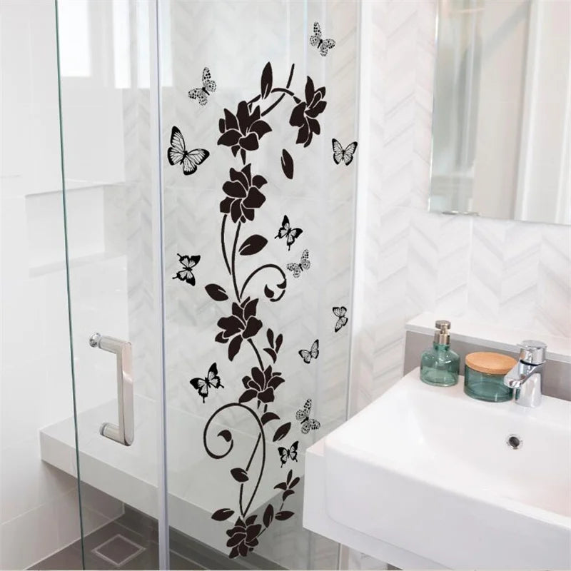 A glass shower door features a black flower and butterfly vine wall sticker design.