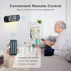 A woman is using a remote control to gently click and control a digital wall clock.