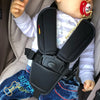 A baby is wearing a black safety belt cushion cover designed for a stroller or car seat.