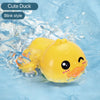 A yellow cute duck bath toy with a blink style face is floating in clear water.