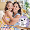 A smiling mother and daughter hugging a purple crochet hedgehog doll with an inspirational card.