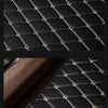 Close-up view of black quilted PU leather car floor mats with gold stitching.