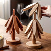 A set of wooden tree-shaped heat-resistant trivets displayed on a wooden surface.