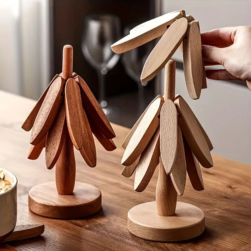 A set of wooden tree-shaped heat-resistant trivets displayed on a wooden surface.