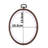A round wooden embroidery hoop with a clear plastic cover and a metal hook for cross-stitch and needlework.
